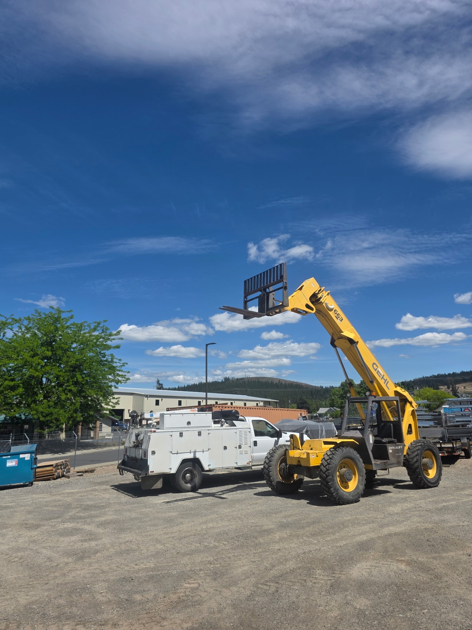 Gehl 663 telehandler with boom raised next to an SE Mobile Repair service truck at a job site near Spokane, WA